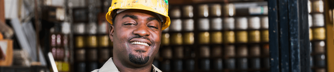 Un homme afro-américain portant un casque protecteur et souriant à l’appareil photo