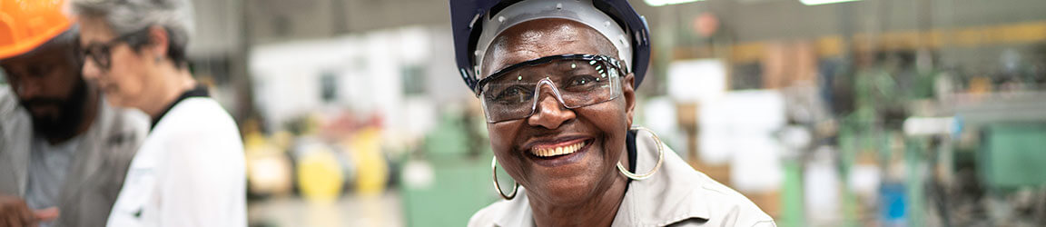 African American woman in manufacturing smiling at camera